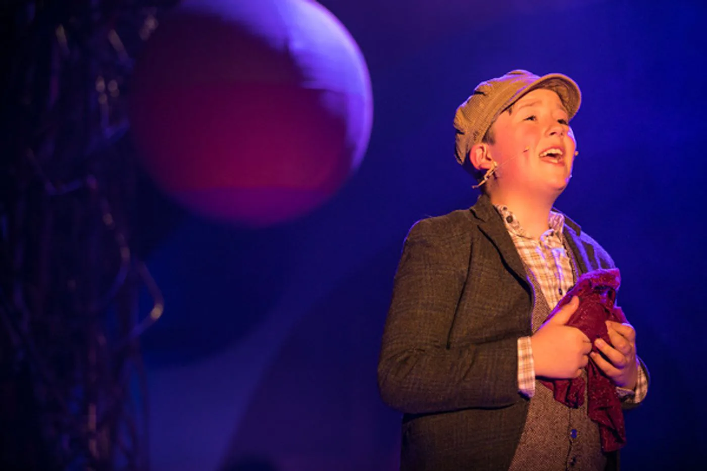 James singing beneath blue and violet stage light.