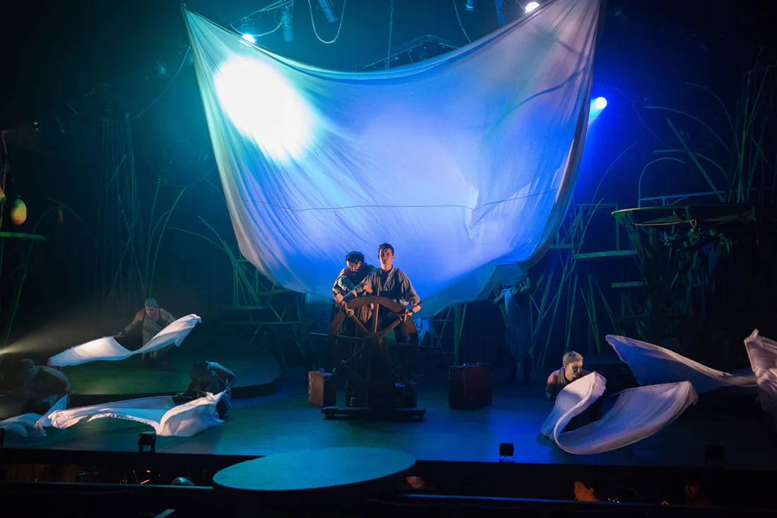 The company creating an ocean voyage beneath a billowing sail.