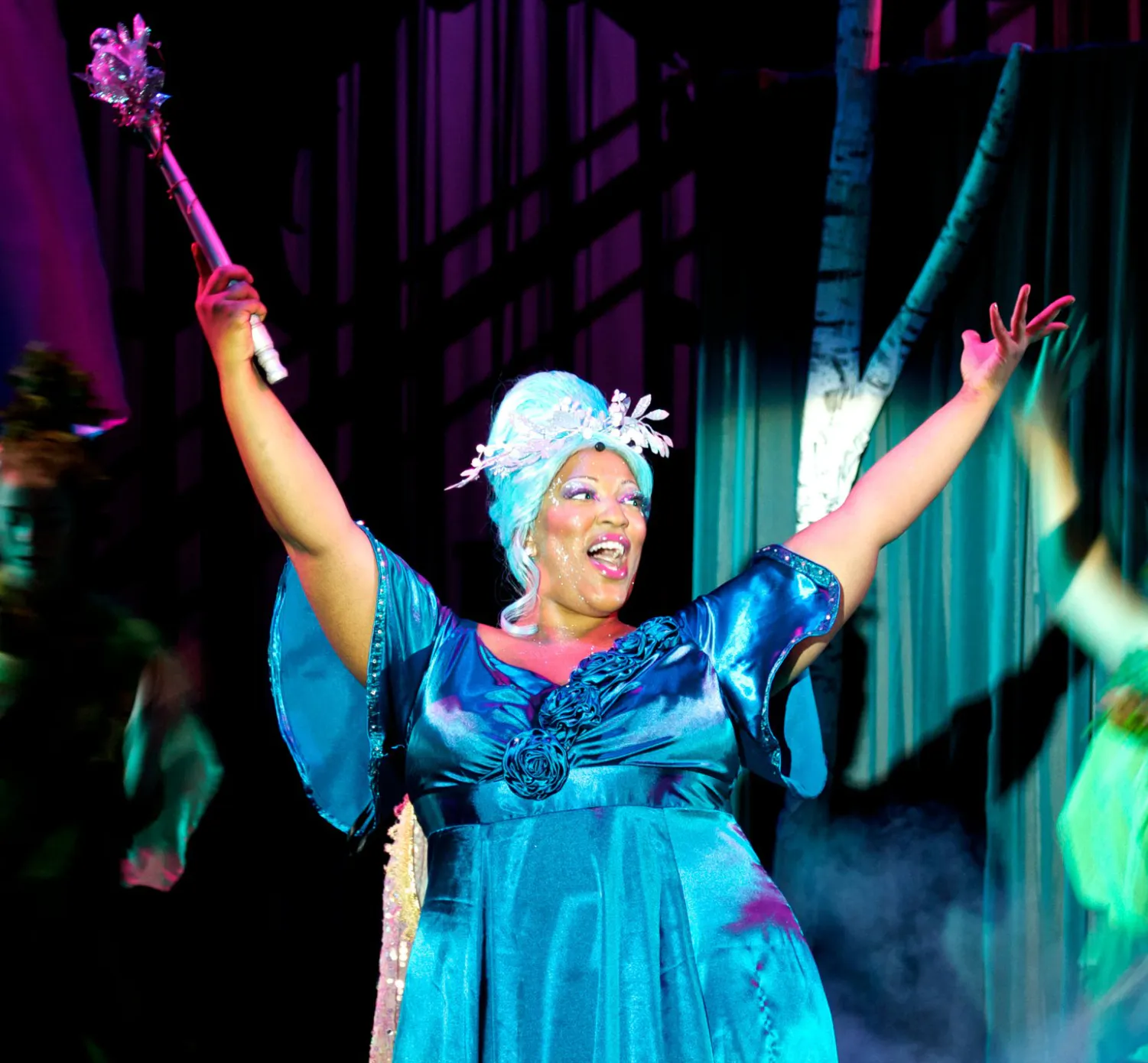 Frenchie Davis as the Fairy Godmother in a blue gown, raising her wand in Cinderella: Enchanted.